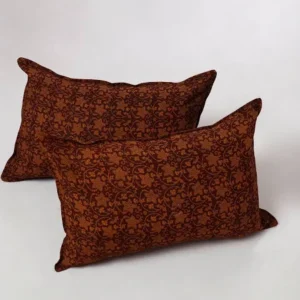 Two rust-patterned cotton throw pillows on white backdrop